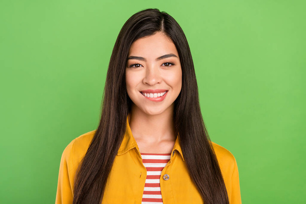 Photo of sweet brunette hairdo young lady bite lip wear yellow shirt isolated on pastel green color background - Foto, afbeelding