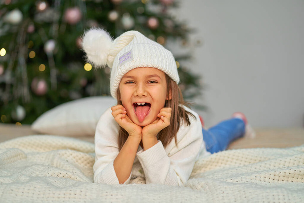 Onnellinen lapsuus, joulutaikasade. Pieni tyttö odottaa joulua ja loma lahjoja - Valokuva, kuva