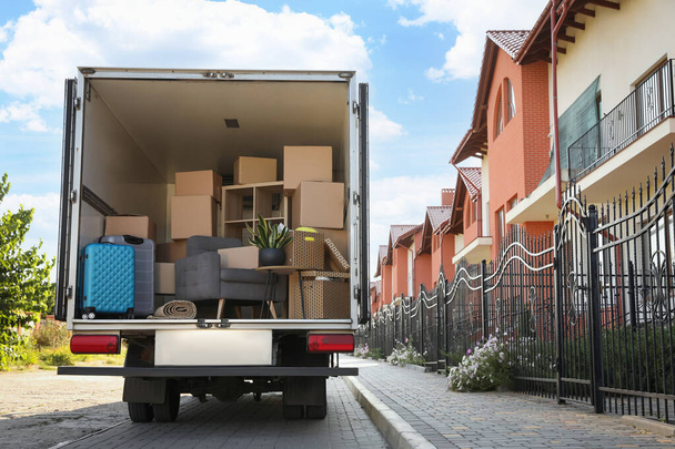 Van full of moving boxes and furniture near house - Φωτογραφία, εικόνα