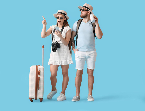 Couple of tourists on color background - Foto, Imagen