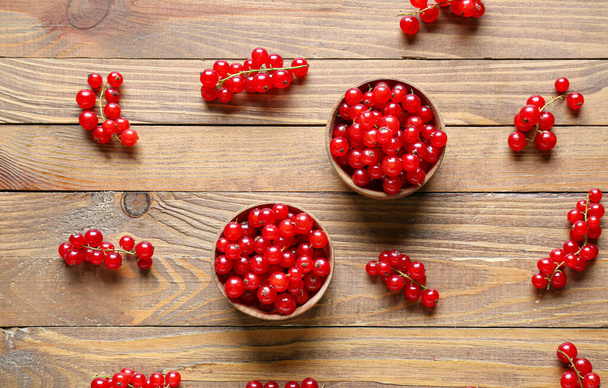 Bowls with fresh red currants on wooden background - Photo, Image