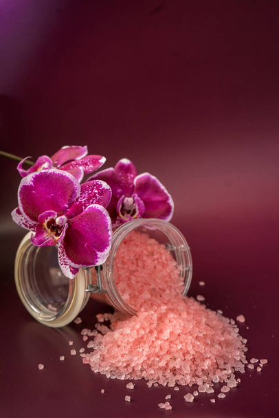Pink bath salt with orchid flower on vinous background . High quality photo - Foto, Imagem