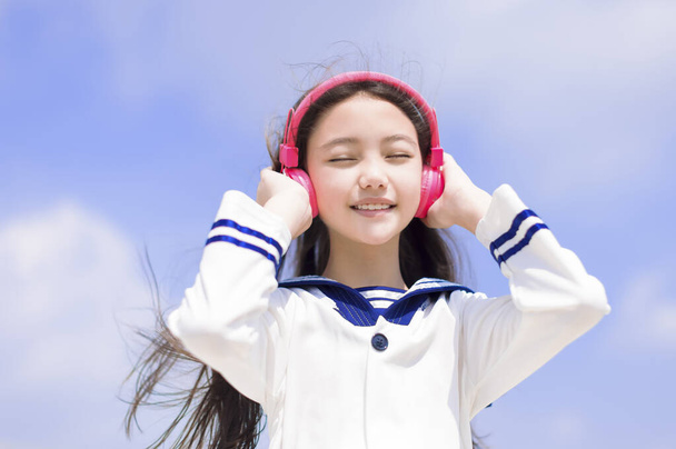 Ευτυχισμένη μαθήτρια απόλαυσε μουσική ακρόασης με ακουστικά - Φωτογραφία, εικόνα
