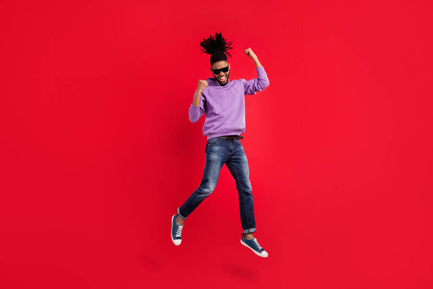 Full length body size photo man with dreadlocks gesuring like winner jumping up isolated vivid red color background - Fotoğraf, Görsel