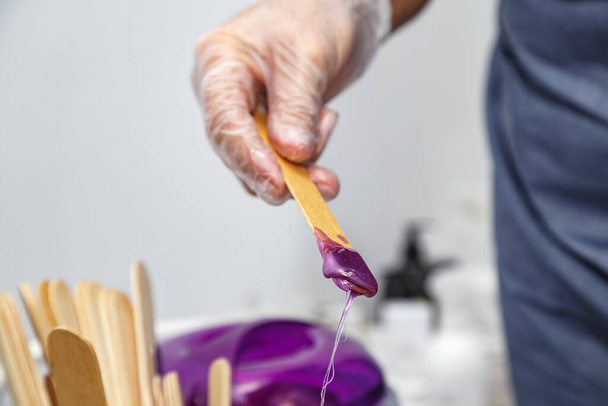 Cire violette fondue sur bâton de bois pour l'épilation - Photo, image