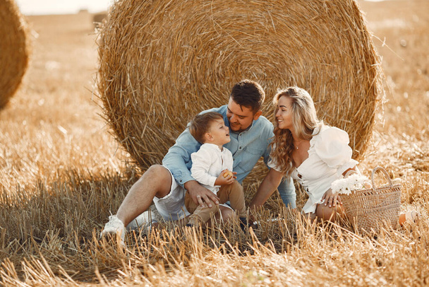 Family in a picnic in a wheat field - Foto, Bild