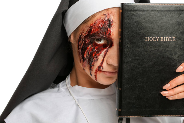 Frau zu Halloween als Nonne mit Bibel auf weißem Hintergrund verkleidet - Foto, Bild