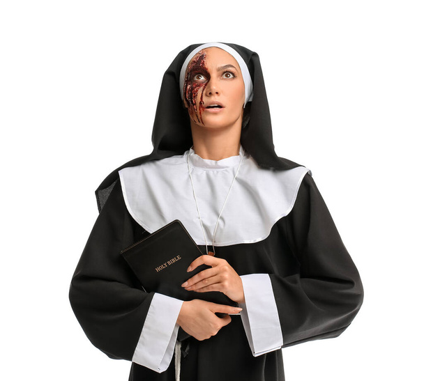 Järkyttynyt nainen pukeutunut Halloween nunna Raamattu valkoisella taustalla - Valokuva, kuva