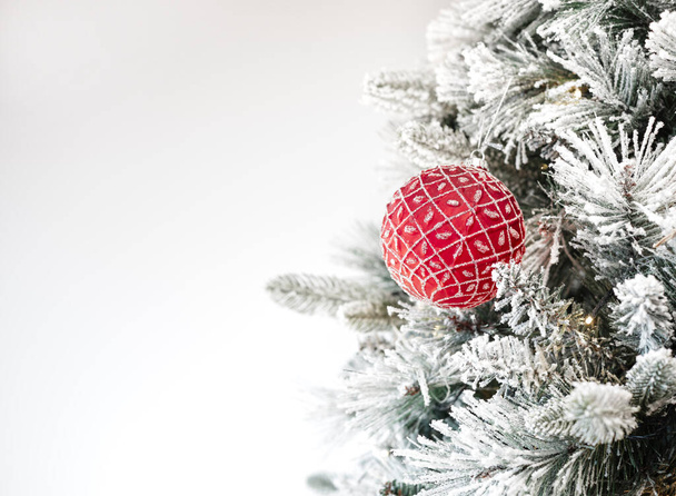 Weihnachtsbaum geschmückt mit traditionellem Weihnachtsschmuck, beleuchtet von Weihnachtslichtern, die mit einem Spiel von Schatten und Lichtern aufleuchten und frohe Weihnachten wünschen. Hintergrund mit weißer Farbe - Foto, Bild