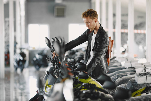 Handsome man choosing a motorcycle to buy - 写真・画像