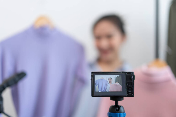 Concepto de compra en vivo una cámara digital que graba un video de una vendedora y se conecta con un dispositivo para transmitir una compra en vivo. - Foto, Imagen