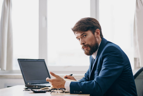 barbudo hombre sentado en un escritorio delante de un ordenador portátil estrés ira profesional - Foto, Imagen