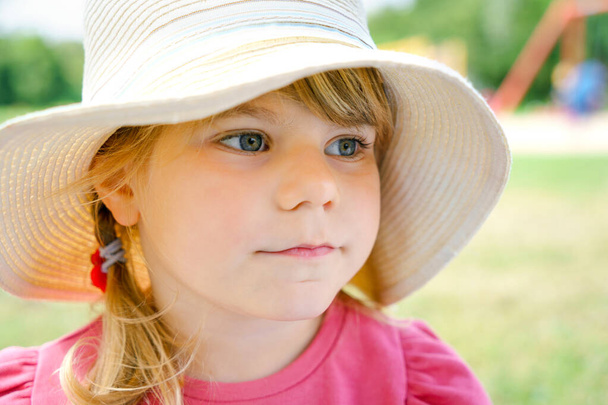 Hasır şapkalı anaokulu kızının portresi. Sevimli mutlu küçük çocuk kameraya bakıyor ve gülümsüyor. Ailecek yaz tatiline çıkmış güzel bir kız.. - Fotoğraf, Görsel