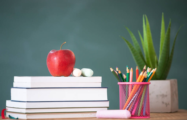 Back to school background with books and apple over blackboard - Photo, Image