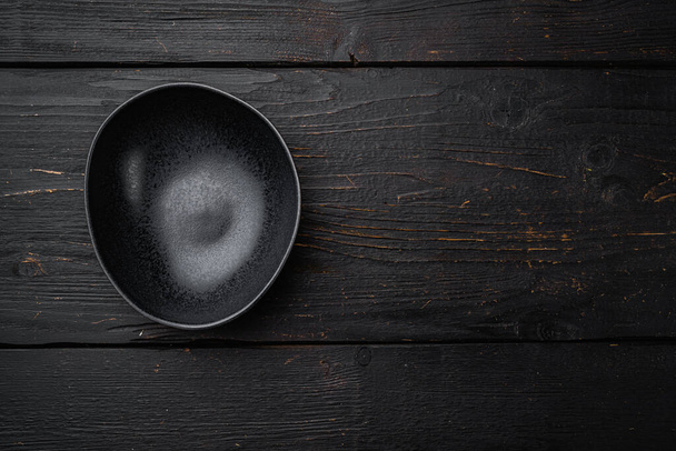 Black bowl set, with copy space for text or food, with copy space for text or food, top view flat lay, on black wooden table background - Photo, Image