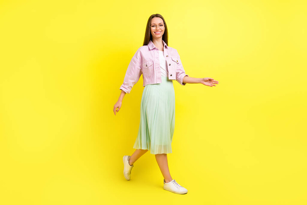 Full length body size view of attractive cheerful girl walking good mood isolated over bright yellow color background - Foto, Imagem