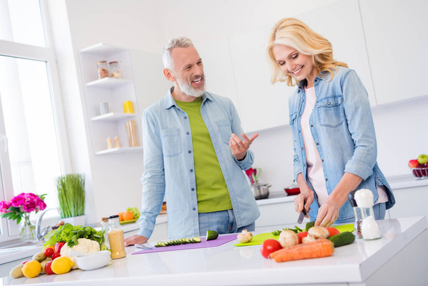 Photo of sweet charming mature lovers dressed jeans shirt talking cooking tasty dish smiling indoors room home - Foto, immagini
