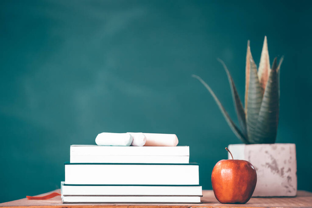 Back to school background with books and apple over blackboard - Foto, imagen