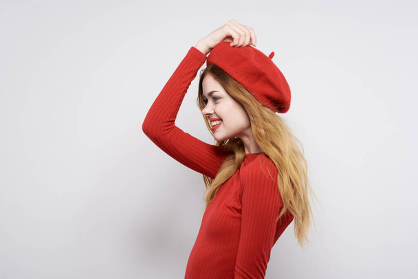 όμορφη γυναίκα με ένα κόκκινο καπέλο στο κεφάλι του glamor φως φόντο - Φωτογραφία, εικόνα