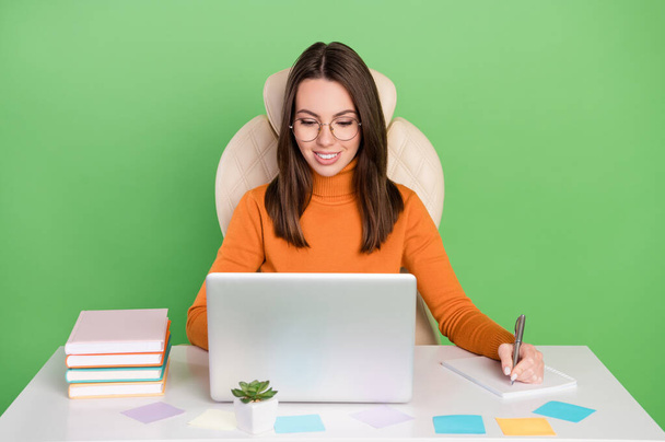 Portrait of attractive cheery focused skilled confident girl working writing to-do list planning isolated over bright green color background - Φωτογραφία, εικόνα