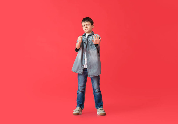 Cute little boy with imaginary steering wheel on color background - Fotografie, Obrázek