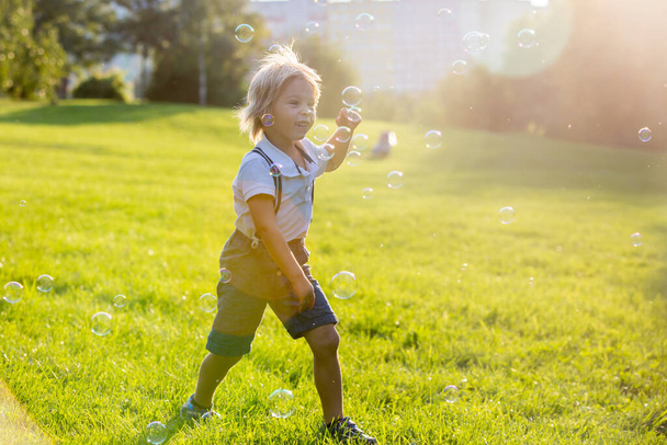 Cute preschool child, playing in the park on sunset - Foto, Imagen