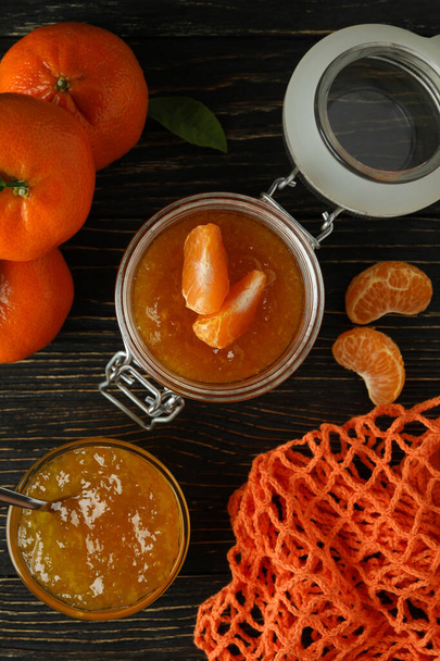Mermelada de mandarina e ingredientes sobre fondo rústico de madera - Foto, imagen