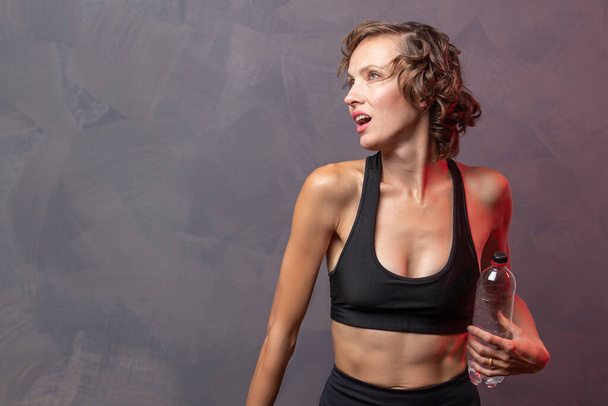 Portrait of woman taking break from working out  and drink water. Sporty girl with water banner - Foto, Imagem