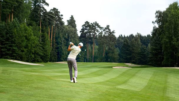 Nuori golfaaja univormussa pelaa golfia ulkona - Valokuva, kuva