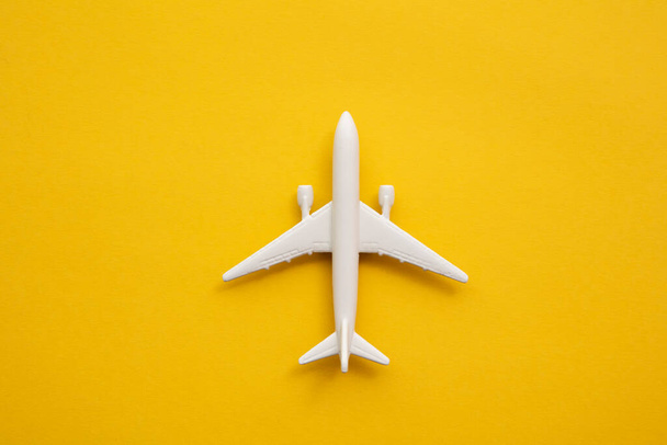 White passenger airplane on a summer yellow background. Travel and vacation background - Foto, afbeelding