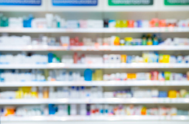 Homályos gyógyszertári háttér. Homályos gyógyszerek a polcokon a gyógyszertárban. - Fotó, kép