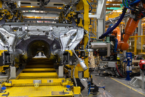 The robot makes welding of the car body. Assembly line. Automobile plant. - Photo, Image