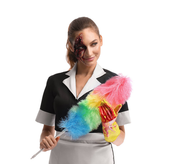 Femme habillée pour Halloween comme femme de chambre avec brosse à poussière sur fond blanc - Photo, image
