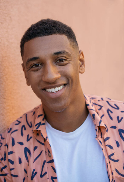Ritratto ravvicinato di giovane uomo afroamericano sorridente con denti bianchi che indossa indumenti casual guardando la fotocamera isolata sullo sfondo - Foto, immagini