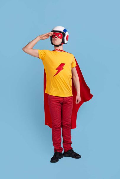 Funny superhero in helmet saluting - Фото, изображение