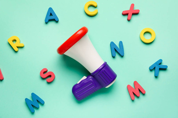 Toy megaphone with letters on color background - Foto, Imagem
