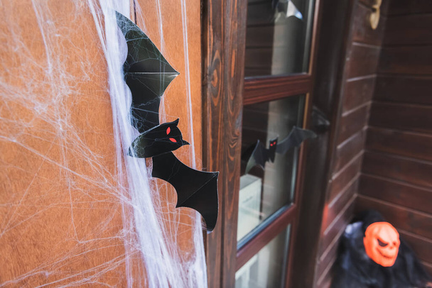puerta de la casa decorada con red de araña y papel negro murciélago cortado - Foto, Imagen