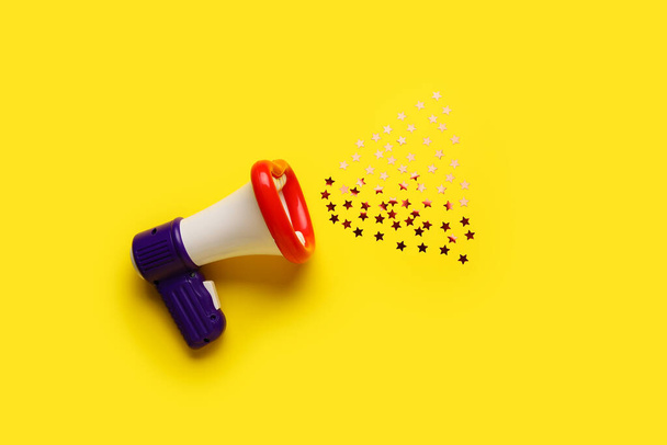 Megáfono de juguete con confeti sobre fondo de color - Foto, imagen