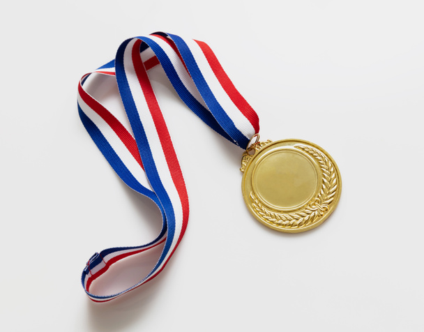 Number one gold medal. Champion first place winner athlete. Prize in sport trophy award and red and blue ribbon isolated on white background. Blank space and laurel wreath, template - Photo, Image