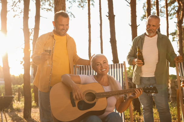 Mature people with guitar at barbecue party on summer day - Photo, Image
