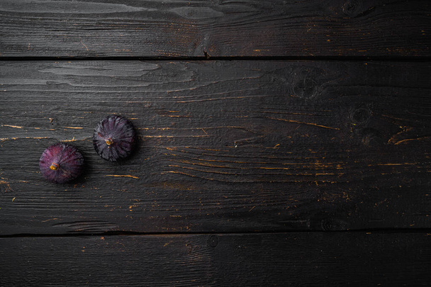 Набор свежих спелых инжиров, на фоне черного деревянного стола, вид сверху плоский, с копировальным пространством для текста - Фото, изображение