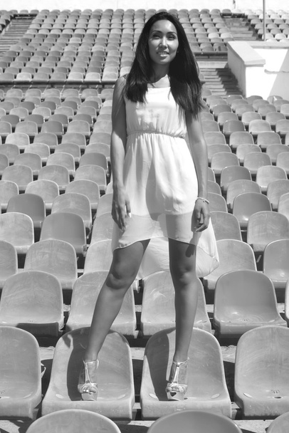 Modelo asiático Posando no estádio em pé sobre os assentos brilhantes
 - Foto, Imagem