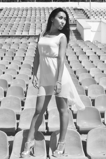 Modelo asiático Posando no estádio em pé sobre os assentos brilhantes
 - Foto, Imagem