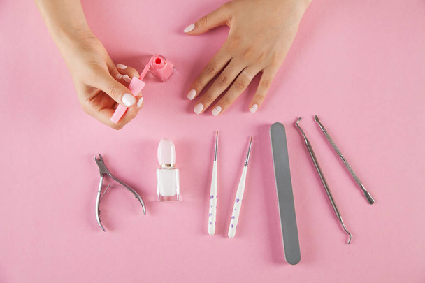 Manicure accessories on an isolated pink background. Woman hands. - Foto, Imagem