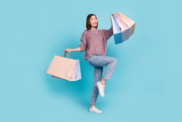 Photo of carefree store client lady dance hold bargains wear pullover jeans shoes isolated blue color background - Foto, imagen