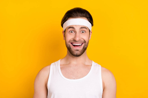 Portrait of attractive amazed cheerful guy sportsman good mood isolated over bright yellow color background - Foto, immagini