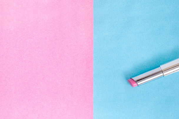 Lápiz labial rosa, maquillaje plano sobre fondo rosa y azul - Foto, Imagen