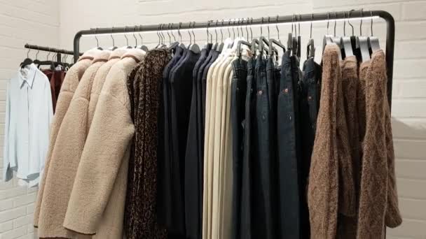 Horní pohled na stojan s podzimní kolekcí dámského oblečení v módní barevné paletě v obchodě. - Záběry, video
