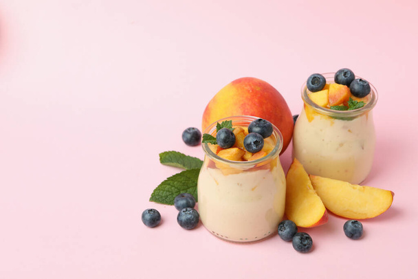 ピンクの背景に桃ヨーグルトと健康食品の概念 - 写真・画像