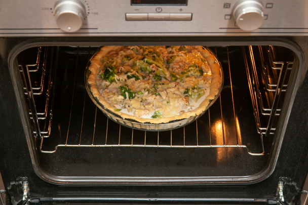 Open shortbread taart met kip en broccoli, bestrooid met kaas, gebakken in de oven. - Foto, afbeelding